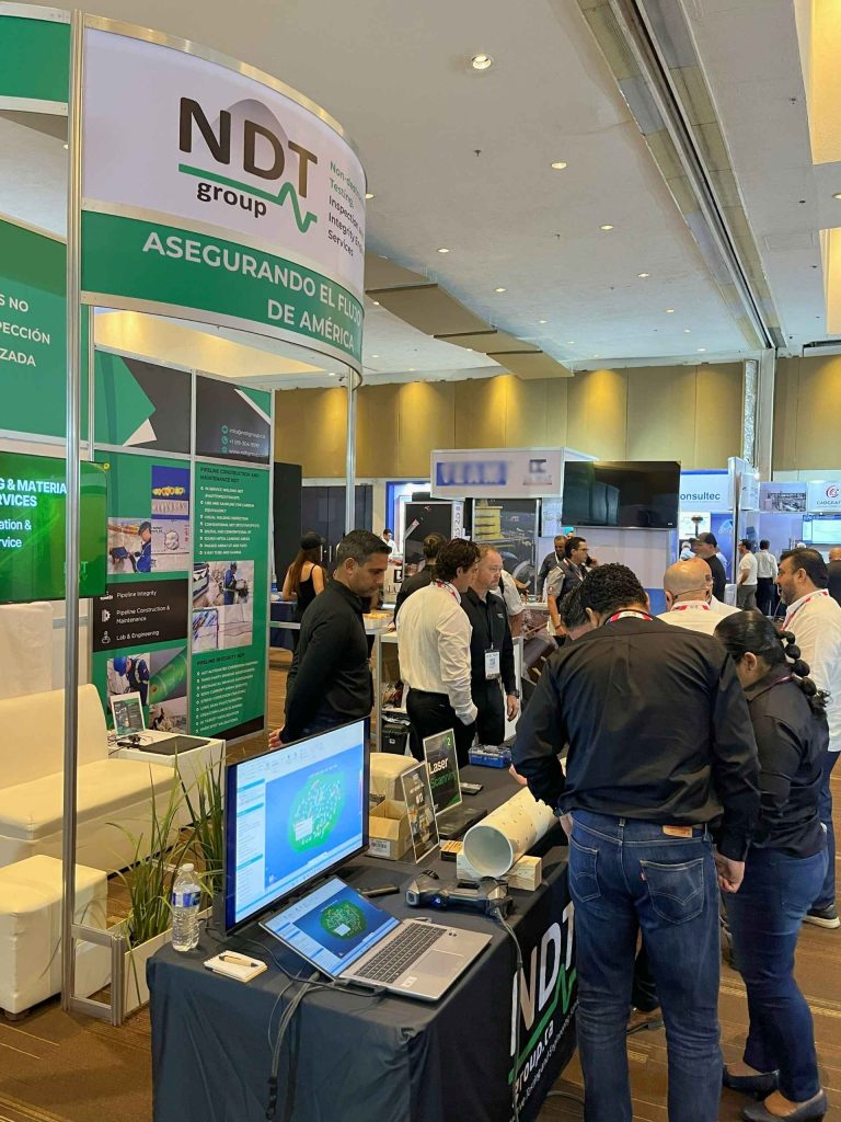 Attendees gathered around NDT Group booth during live technology demonstrations.